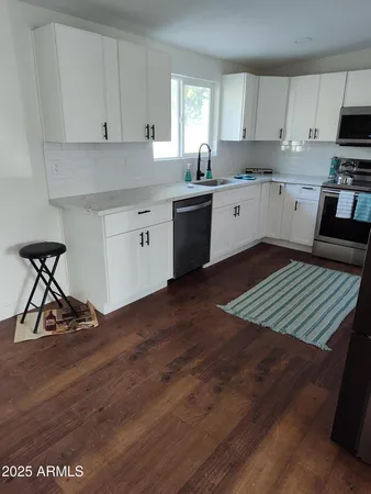 a kitchen with a sink a stove and cabinets