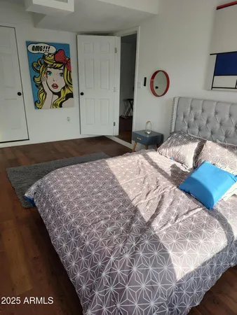 a bedroom with a bed and painting on the wall