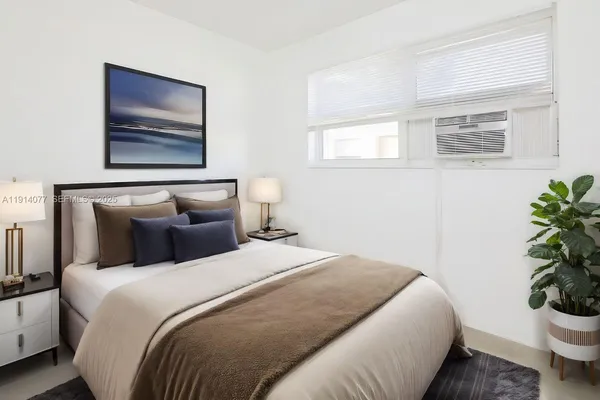 a bedroom with bed painting on the wall and a potted plant