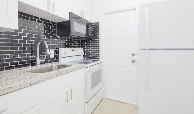 309 Phippen Waiters Road, Unit 1 Dania Beach, FL 33004 - Photo 5 of 8 a bathroom with a granite countertop sink a toilet and shower