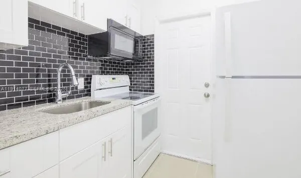 a bathroom with a granite countertop sink a toilet and shower