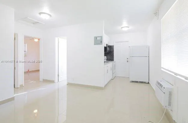 a view of a kitchen with a refrigerator and white cabinets