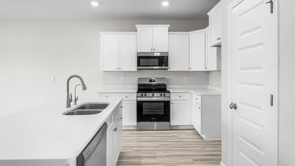 a kitchen with stainless steel appliances granite countertop a stove a sink and a refrigerator