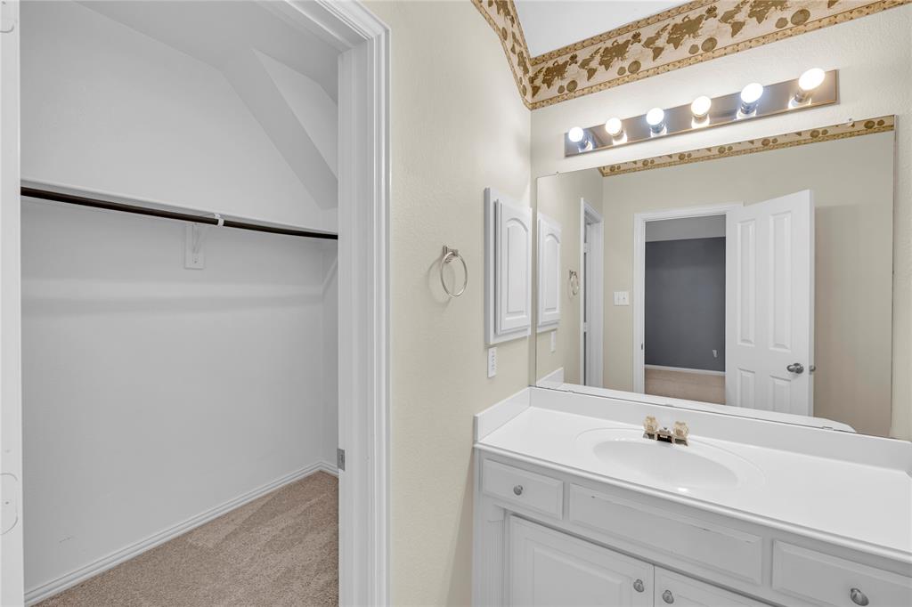 3920 Autumn Lane Bedford, TX 76021 - Photo 30 of 36 Bathroom vanity featuring a white countertop with an integrated sink and brass-finish faucet