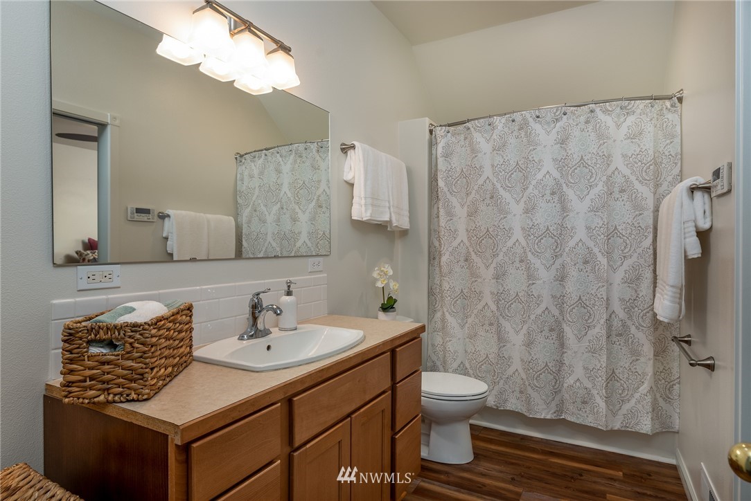 672 East Smith Road Bellingham, WA 98226 - Photo 11 of 25 a bathroom with a sink toilet a mirror and shower curtain
