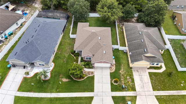 an aerial view of residential houses with outdoor space and parking