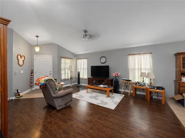 a living room with furniture flat screen tv and wooden floor