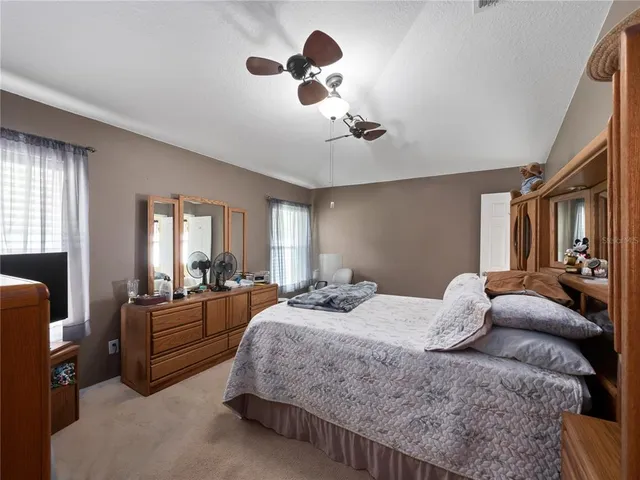 a bedroom with a bed couch chandelier and window