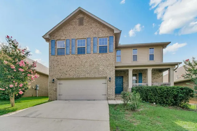 a front view of a house with a garden and plants