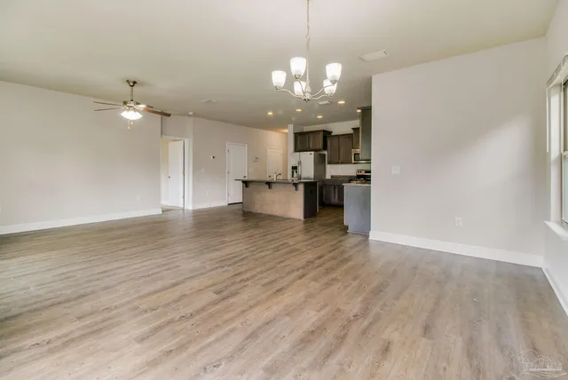 a view of a kitchen with a dishwasher a kitchen island hardwood floor and a ceiling fan