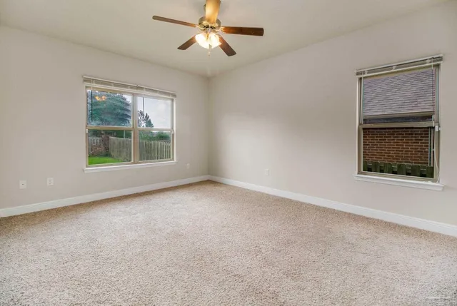 an empty room with a window and a ceiling fan