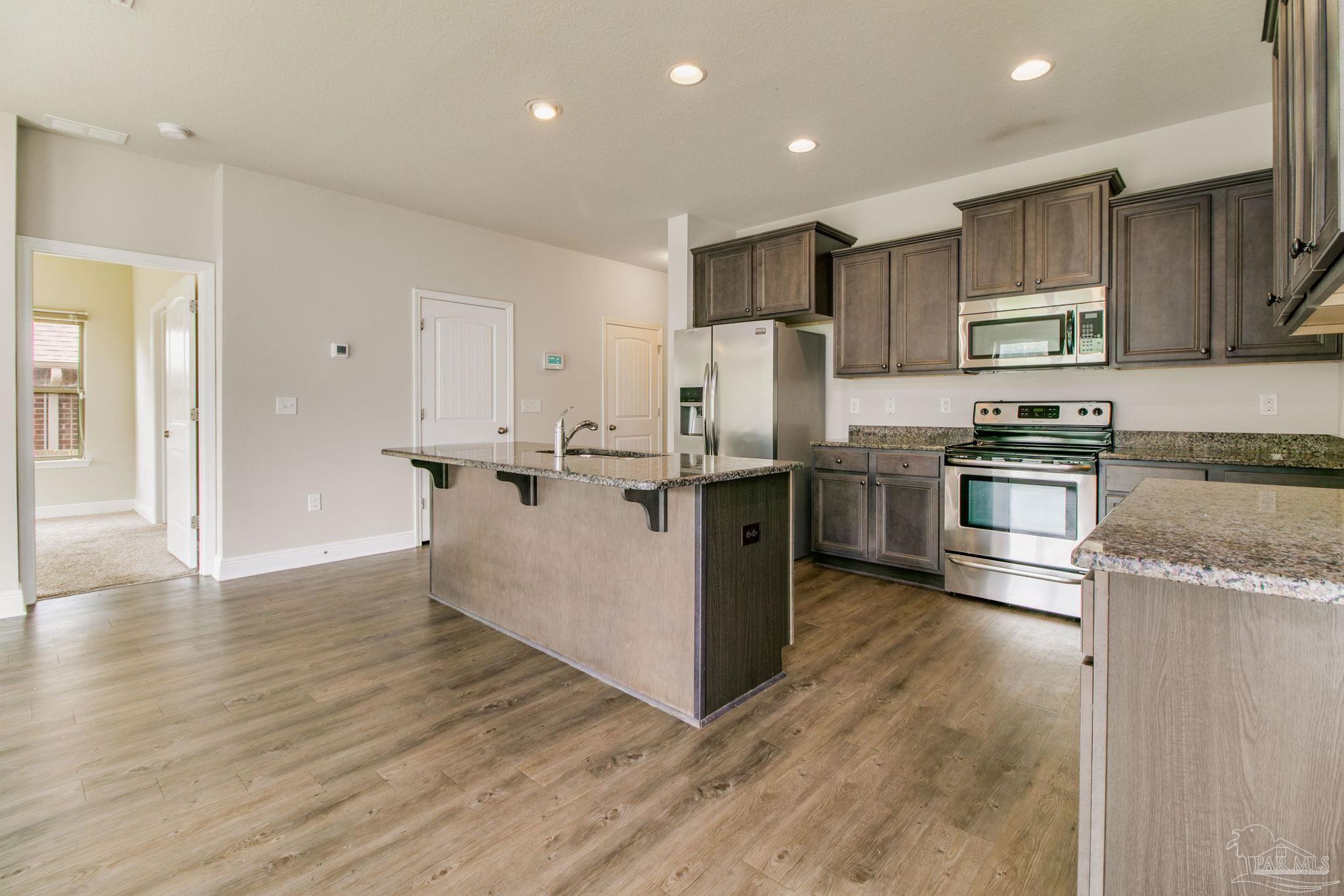 6348 Ladera Trail Pace, FL 32571 - Photo 4 of 50 a kitchen with stainless steel appliances granite countertop a refrigerator a stove and a sink