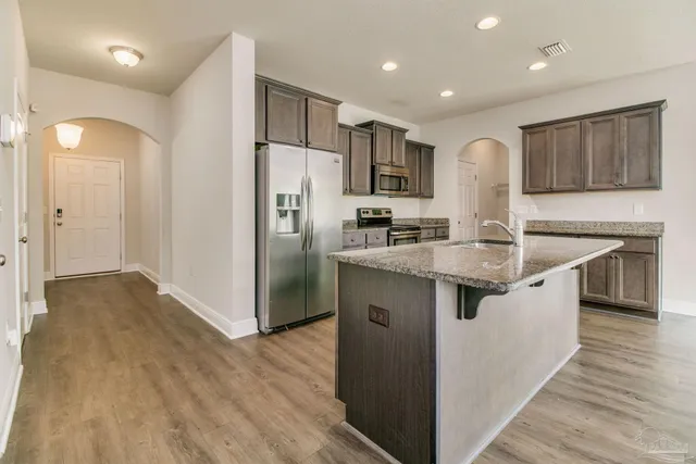 a kitchen with stainless steel appliances granite countertop a sink stove and refrigerator