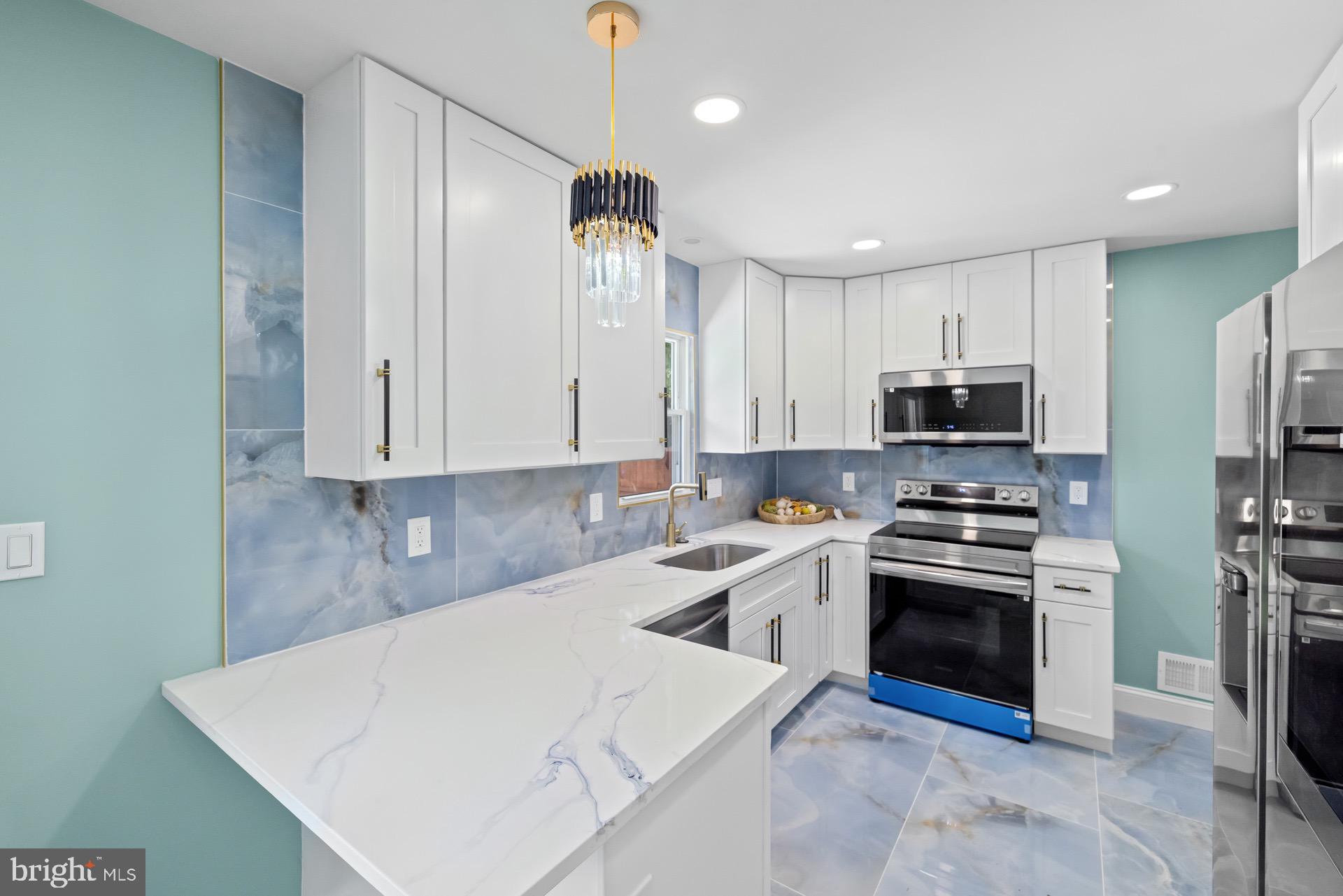 523 Sunset Knoll Road Pasadena, MD 21122 - Photo 11 of 60 a kitchen with stainless steel appliances a stove a sink a refrigerator white cabinets and wooden floor