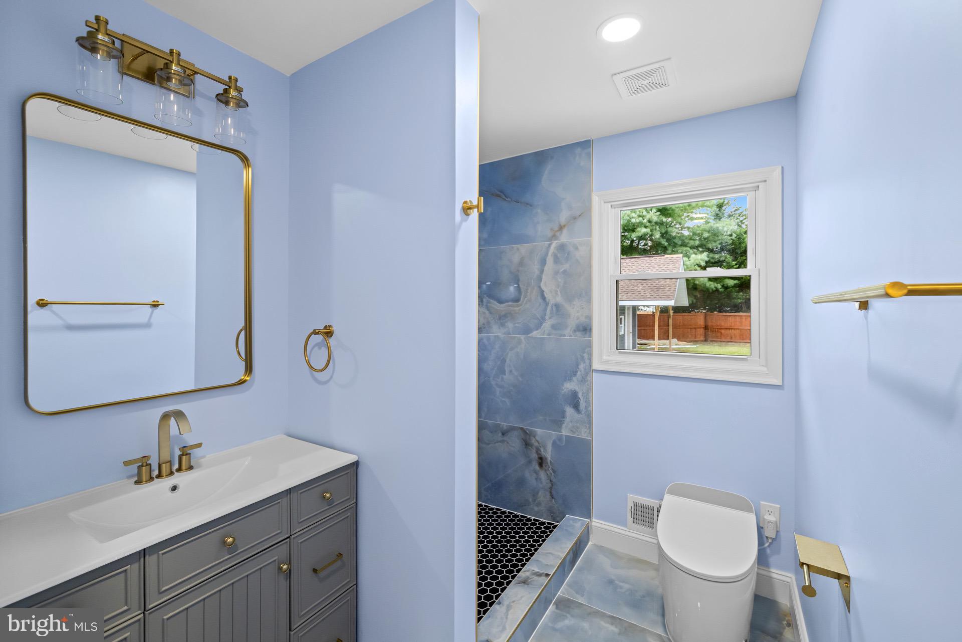 523 Sunset Knoll Road Pasadena, MD 21122 - Photo 26 of 60 a bathroom with a toilet a sink a mirror a window and vanity