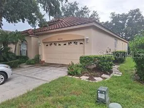 a view of a house with a yard plants and a table under an umbrella