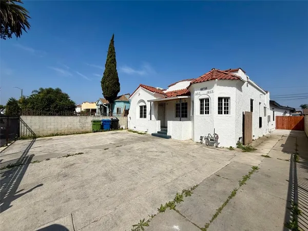 a front view of a house with a dirt yard
