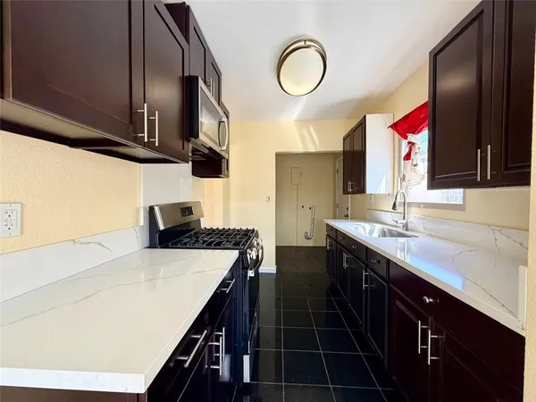 a kitchen with stainless steel appliances a sink stove and cabinets