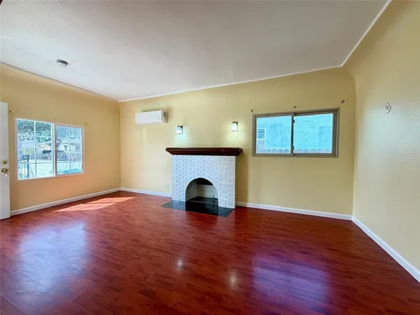 a view of empty room with wooden floor and fireplace