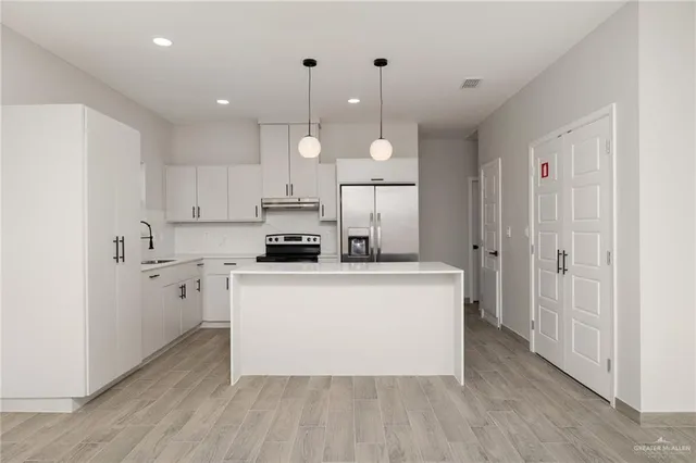 a view of an empty room with wooden floor and window