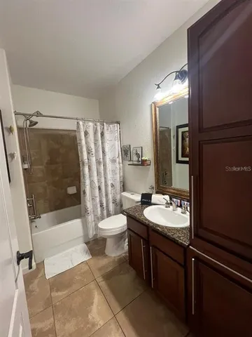 a bathroom with a sink a toilet a mirror and shower