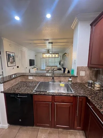 a kitchen with stainless steel appliances granite countertop a sink and a white cabinets