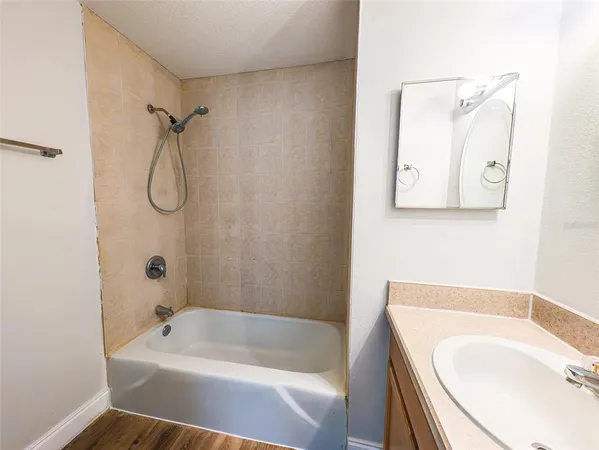 a bathroom with a tub a sink and a shower