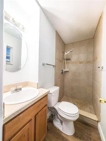 a bathroom with a sink a toilet and shower