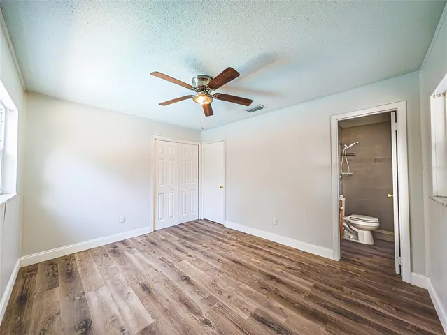 a view of a big room with wooden floor and a bathroom