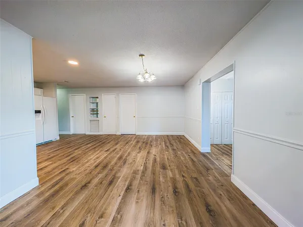 a view of a room with wooden floor and a ceiling fan
