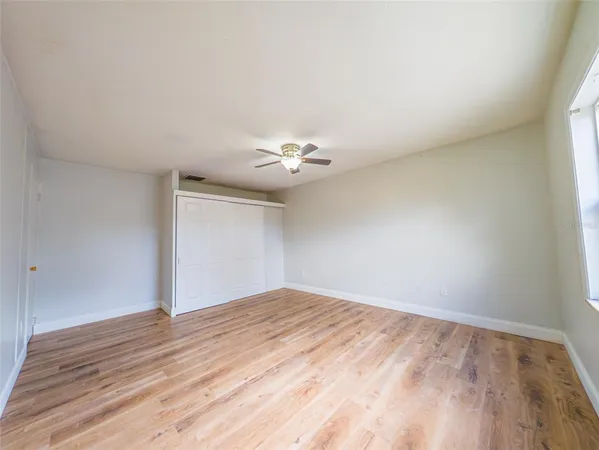a view of empty room with wooden floor