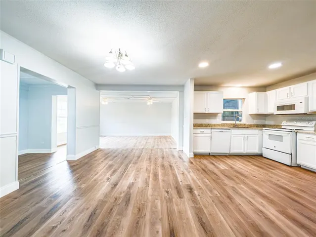 a large kitchen with kitchen island a sink dishwasher a stove and a refrigerator with wooden floor