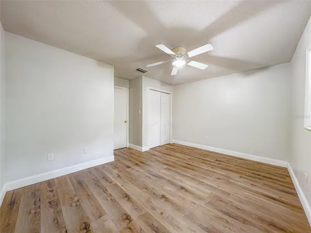 a view of empty room with wooden floor