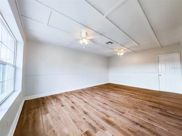 a view of empty room with wooden floor