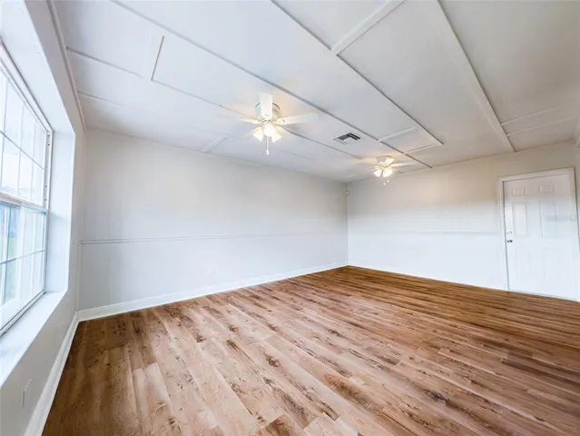a view of empty room with wooden floor