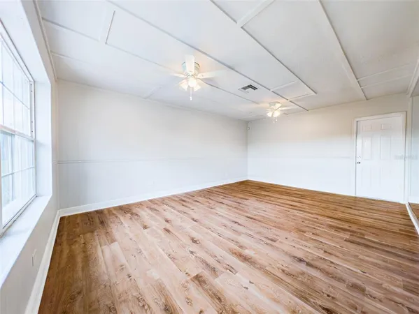 a view of empty room with wooden floor