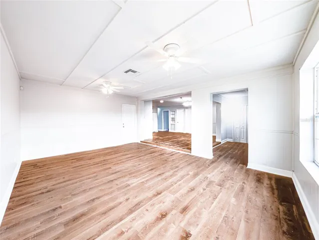 a view of empty room with wooden floor