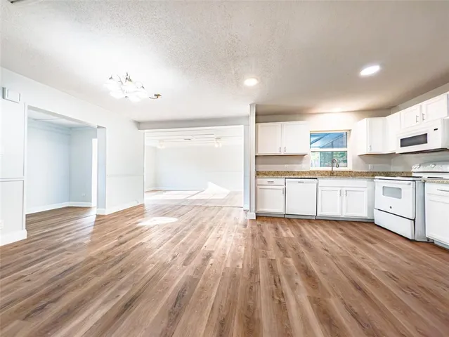 a view of kitchen with wooden floor and electronic appliances