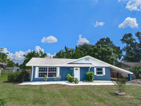 a view of a house with backyard and sitting area