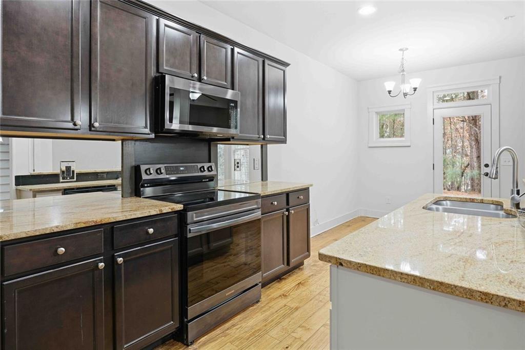 501 Ridge View Crossing Woodstock, GA 30188 - Photo 13 of 44 a kitchen with stainless steel appliances granite countertop a sink stove and microwave
