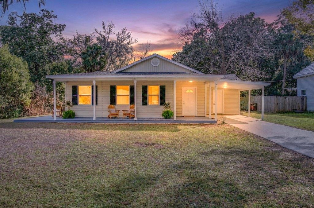 View of front of house featuring a porch, a carport, and concrete driveway