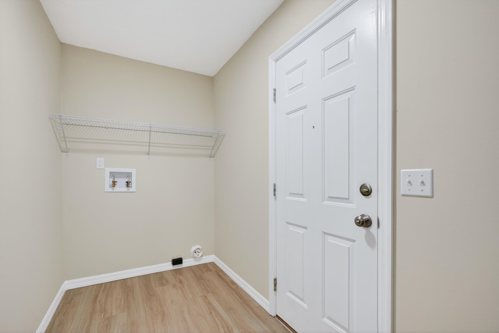 37 Madeore Street St. Augustine, FL 32084 - Photo 40 of 45 Laundry area with light vinyl plank flooring and hookups for a washing machine and dryer.