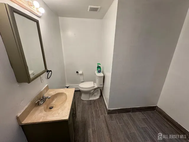 a bathroom with a sink a toilet and a mirror