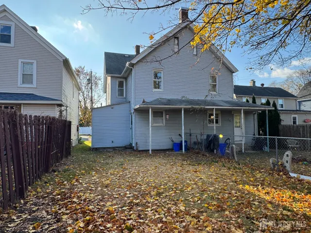 a front view of a house with a garden and chairs