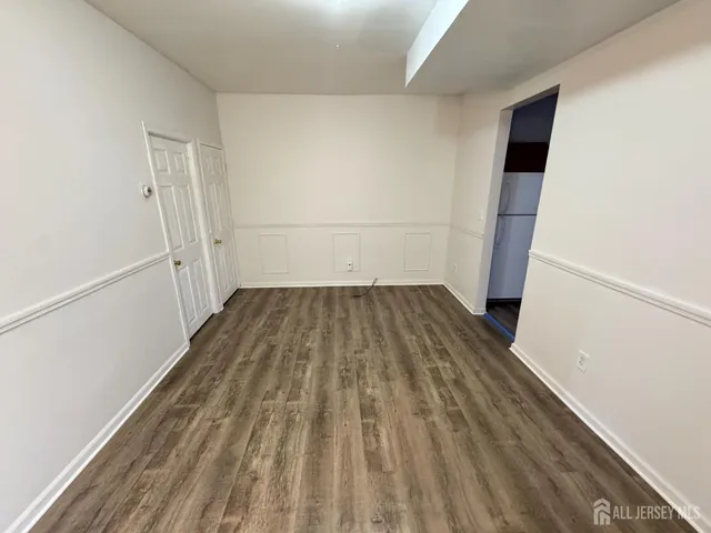an empty room with wooden floor and entrance