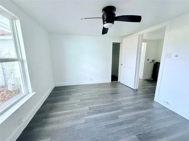a view of an empty room with a window and a ceiling fan
