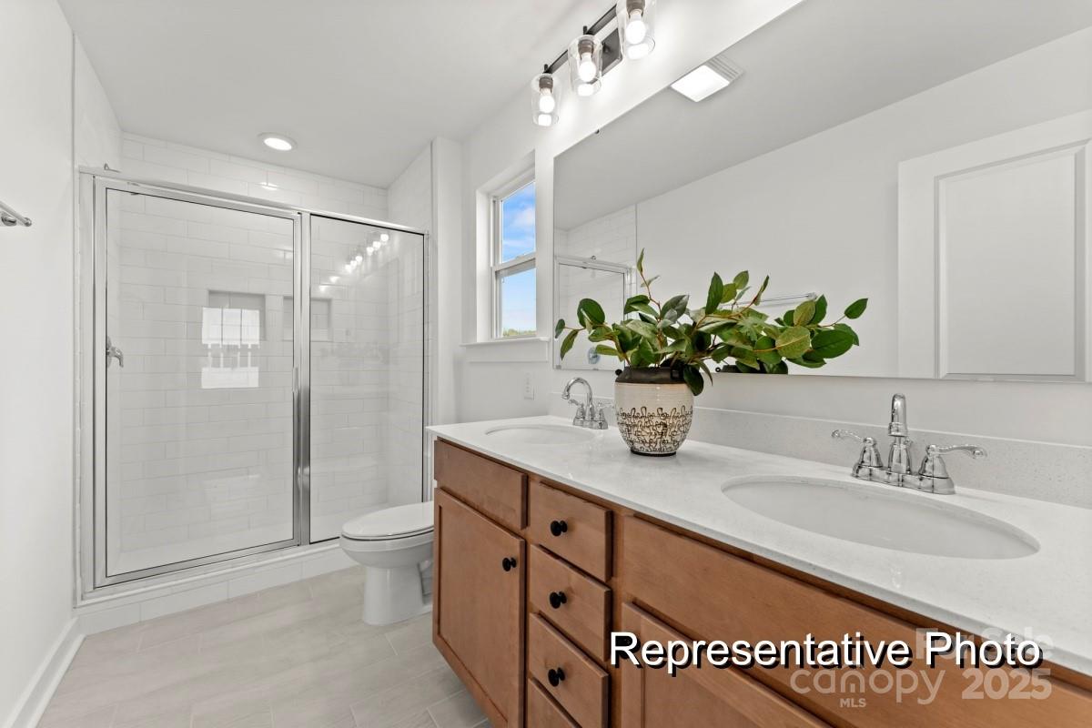 32612 B Millingport Road, Unit 7157 New London, NC 28127 - Photo 17 of 23 a bathroom with a granite countertop sink a shower and a mirror
