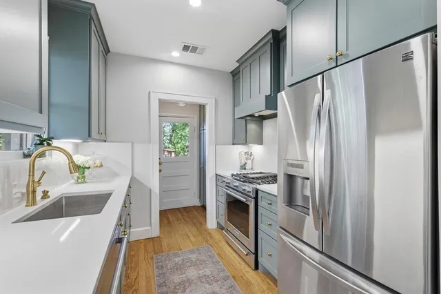 a kitchen with stainless steel appliances a refrigerator sink and stove