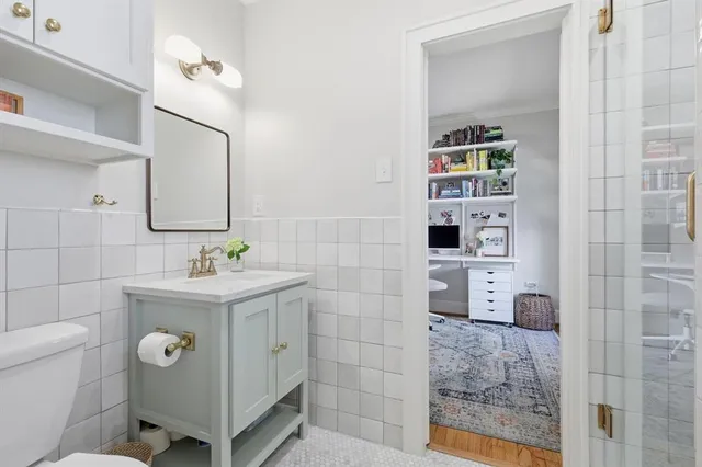 a bathroom with a granite countertop sink a toilet and a mirror