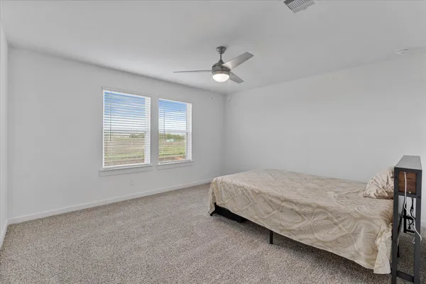 a spacious bedroom with a bed and a window
